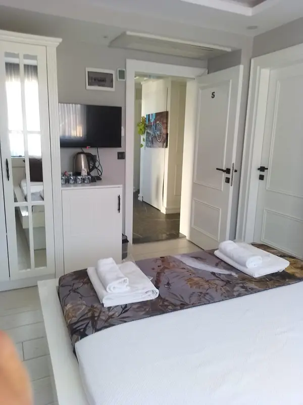Une chambre avec un lit preparé et un espace détente.
