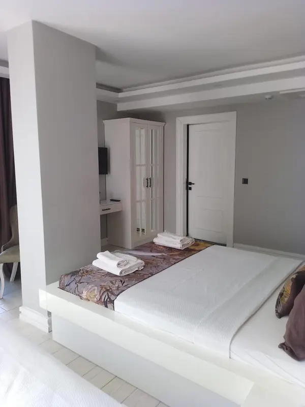 Une chambre lumineuse avec un grand lit recouvert d'une courtepointe décorative.