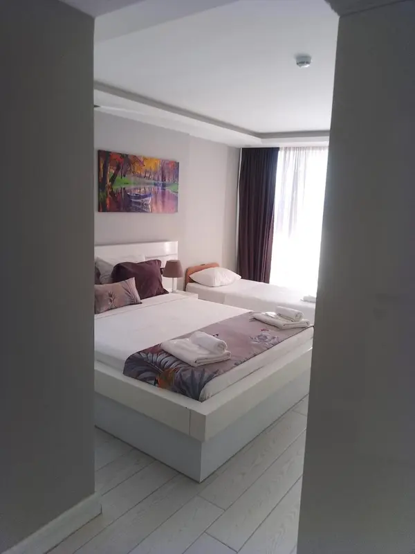 Une chambre lumineuse avec un grand lit et une décoration sobre.