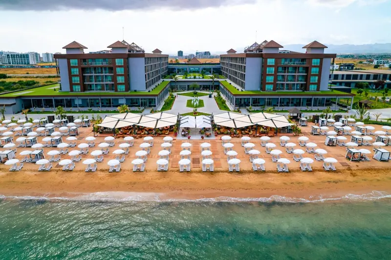 Vue aérienne d'un complexe hôtelier avec une plage et des transats.