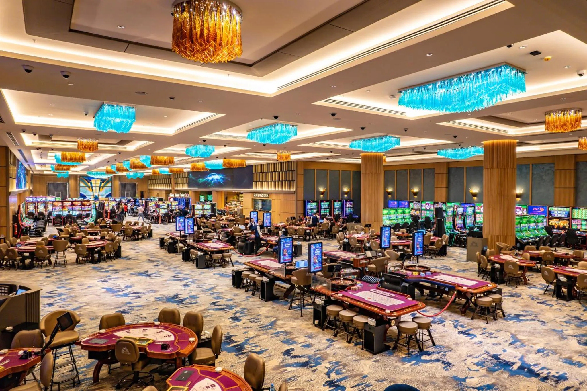 Vaste salle de jeux avec tables et machines à sous.