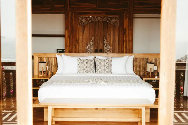 Une chambre lumineuse avec un grand lit recouvert de linge blanc.