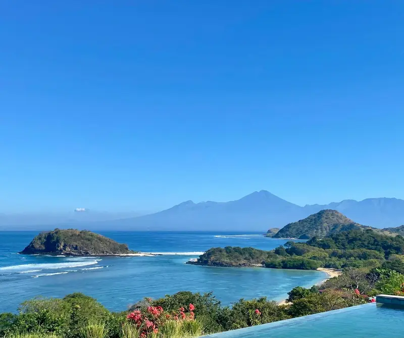 Vue panoramique sur une côte montagneuse et une mer turquoise.