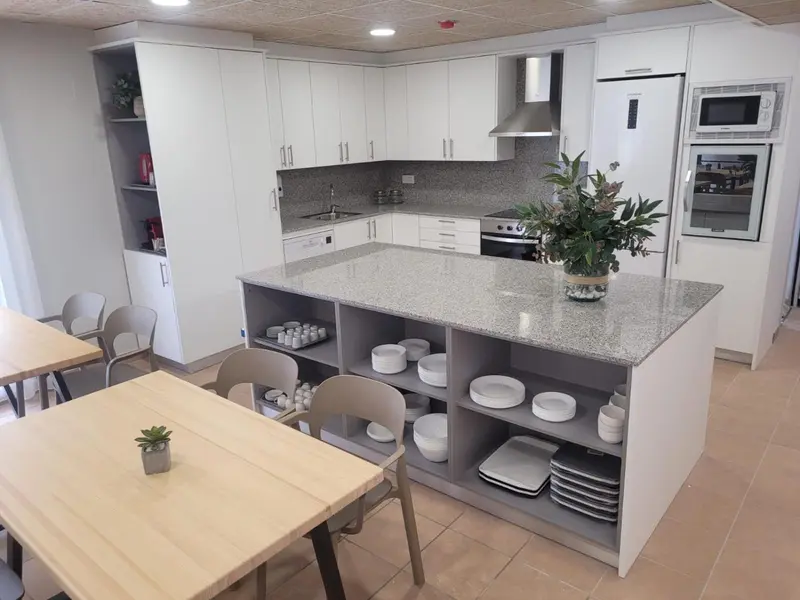 Une cuisine moderne avec un îlot central et des meubles blancs.