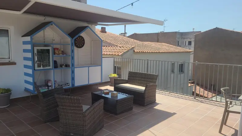 Terrasse aménagée avec mobilier de jardin et étagères décoratives.