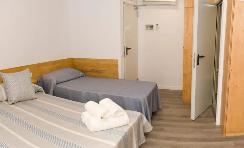 Une chambre avec deux lits simples et un oreiller sur chacun.