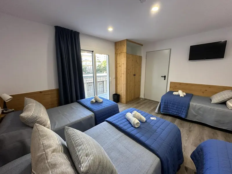 Chambre avec lits simples et accès à une terrasse.