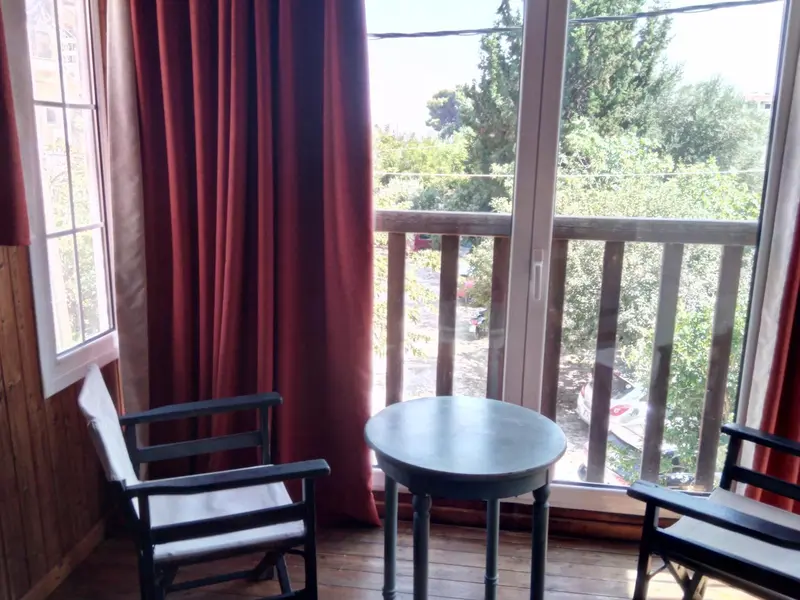 Une pièce lumineuse s'ouvre sur une terrasse avec vue sur la végétation.