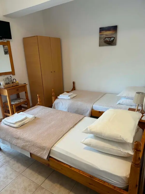 Une chambre avec deux lits simples et une commode.