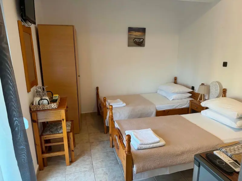 Une chambre avec deux lits simples et une commode.