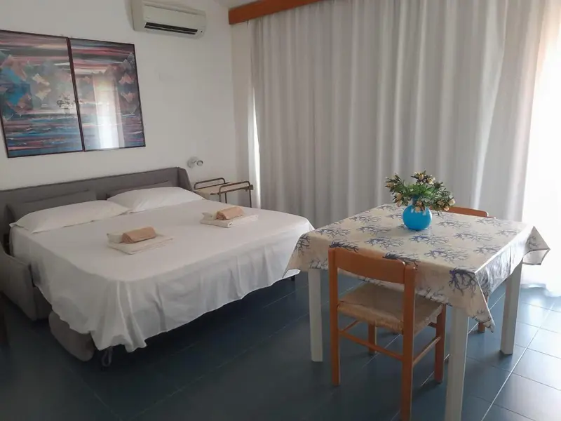 Une chambre lumineuse avec un lit et une petite table.