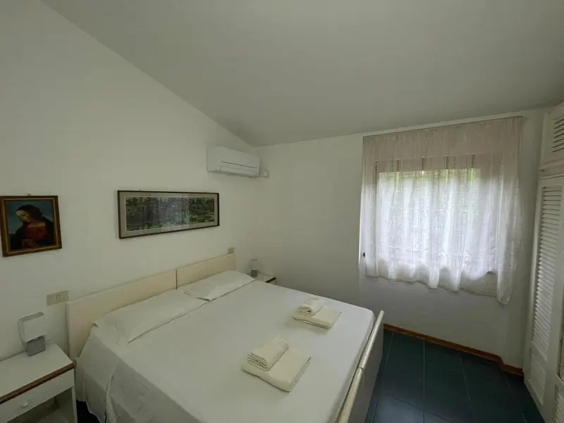 Une chambre lumineuse avec un lit double et une fenêtre.