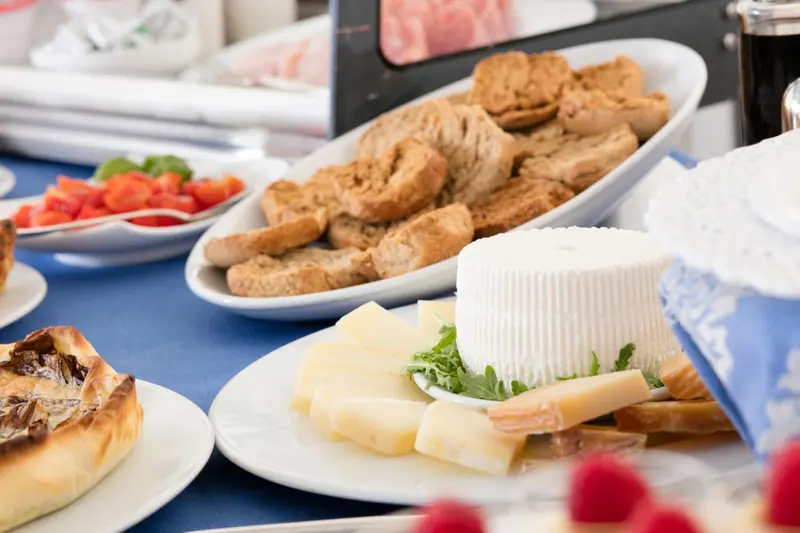 Assortiment de fromages, pains et crudités présentés sur un buffet.