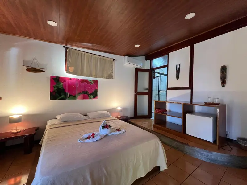 Une chambre lumineuse avec un lit recouvert de fleurs et un décor mural.