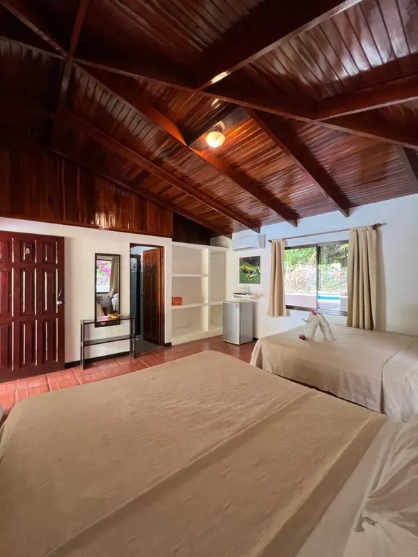 Chambre lumineuse avec lits simples et décoration tropicale.