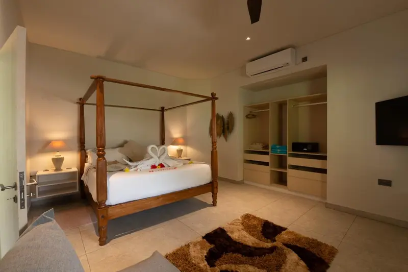 Une chambre lumineuse avec un grand lit à baldaquin décoré de fleurs.