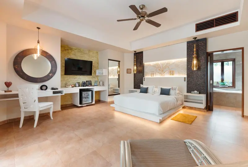 Une chambre lumineuse avec un grand lit et un espace bureau.