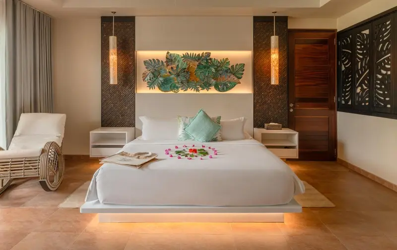 Une chambre lumineuse avec un grand lit décoré de fleurs.