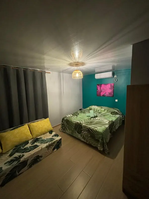 Une chambre à coucher lumineuse avec un lit recouvert d'une couette à motifs.