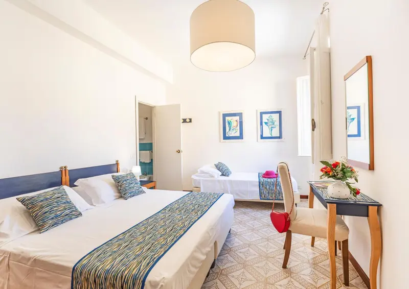 Une chambre lumineuse avec deux lits et une décoration sobre.