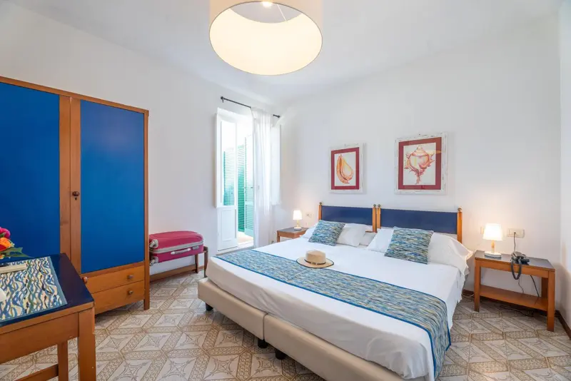 Une chambre lumineuse avec un grand lit et un accès à une terrasse.
