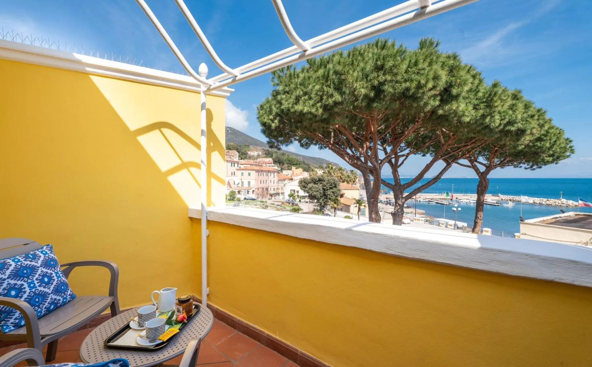 Une terrasse ensoleillée offre une vue sur la mer et les collines environnantes.
