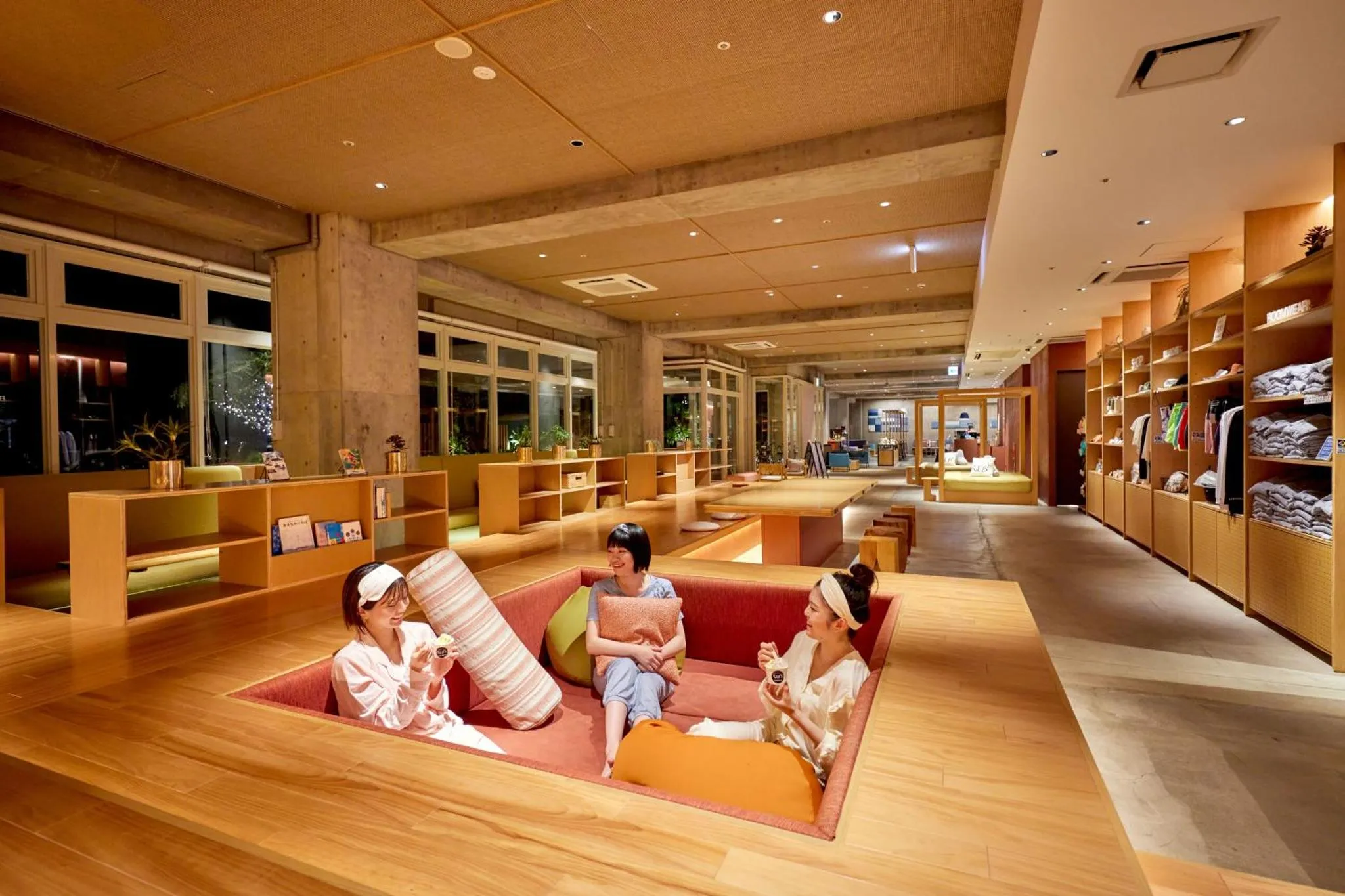 Espace de détente intérieur avec des personnes assises sur des canapés encastrés.