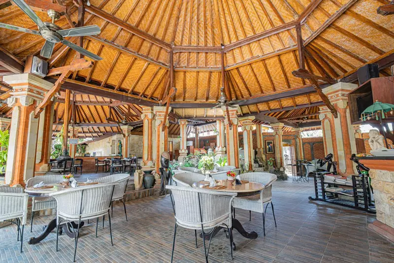 Une salle à manger extérieure avec des tables et des chaises en osier.