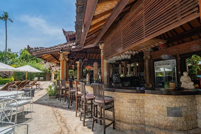 Un bar extérieur avec des tabourets et une décoration soignée.