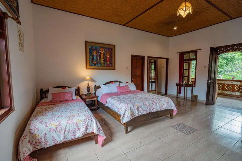 Chambre lumineuse avec deux lits et une décoration florale.