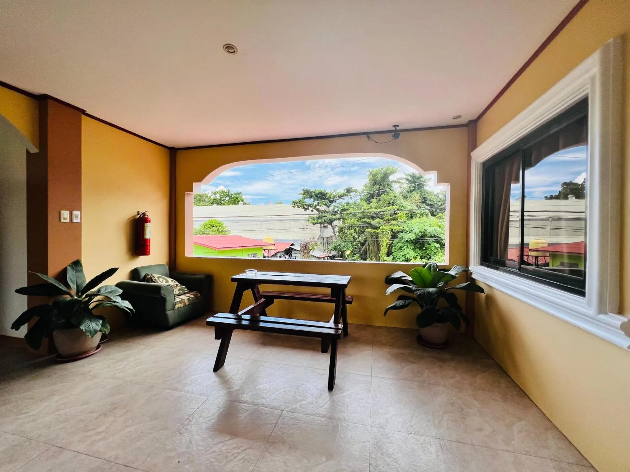 Espace de détente intérieur avec table et canapé près d'une fenêtre.