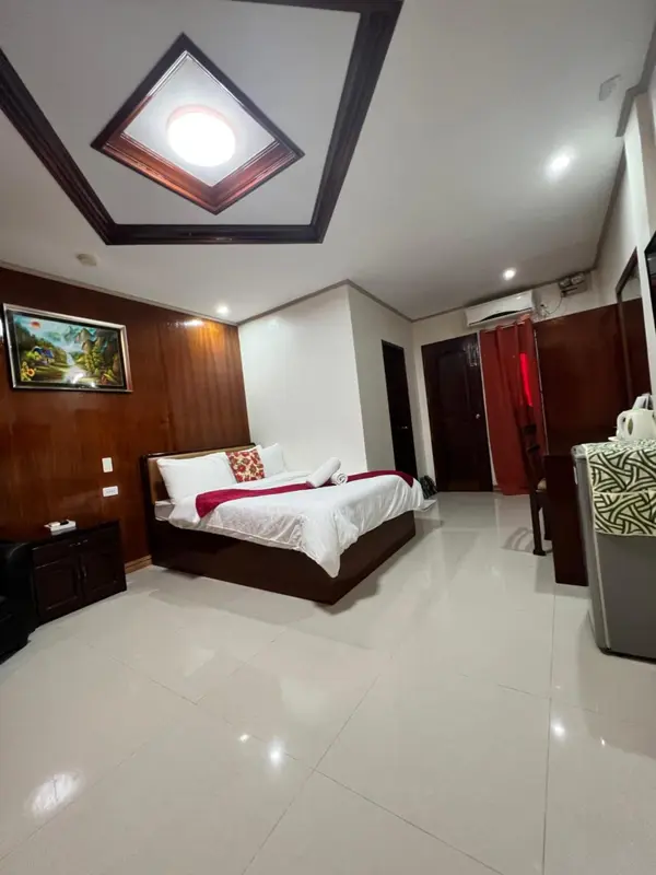 Une chambre lumineuse avec un lit double et une décoration sobre.