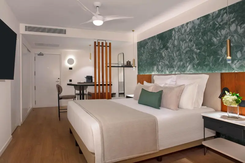 Une chambre lumineuse avec un grand lit et un coin repas.
