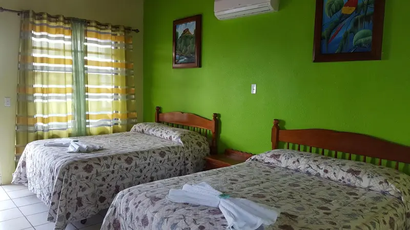 Chambre avec deux lits simples et décoration murale colorée.