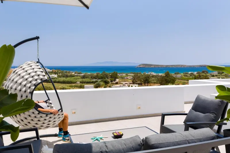 Terrasse avec mobilier d'extérieur et vue sur la mer.