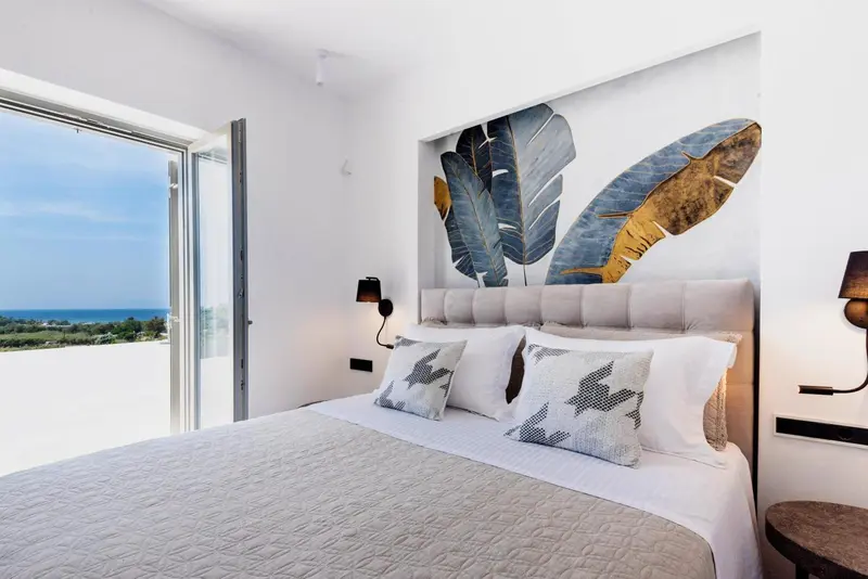 Une chambre lumineuse avec un grand lit et une vue sur la mer.