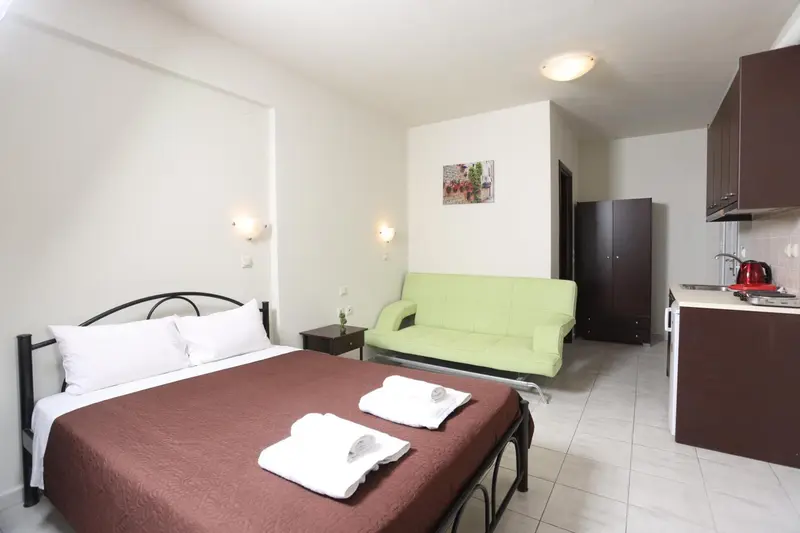 Une chambre avec un lit et un canapé vert d'angle.