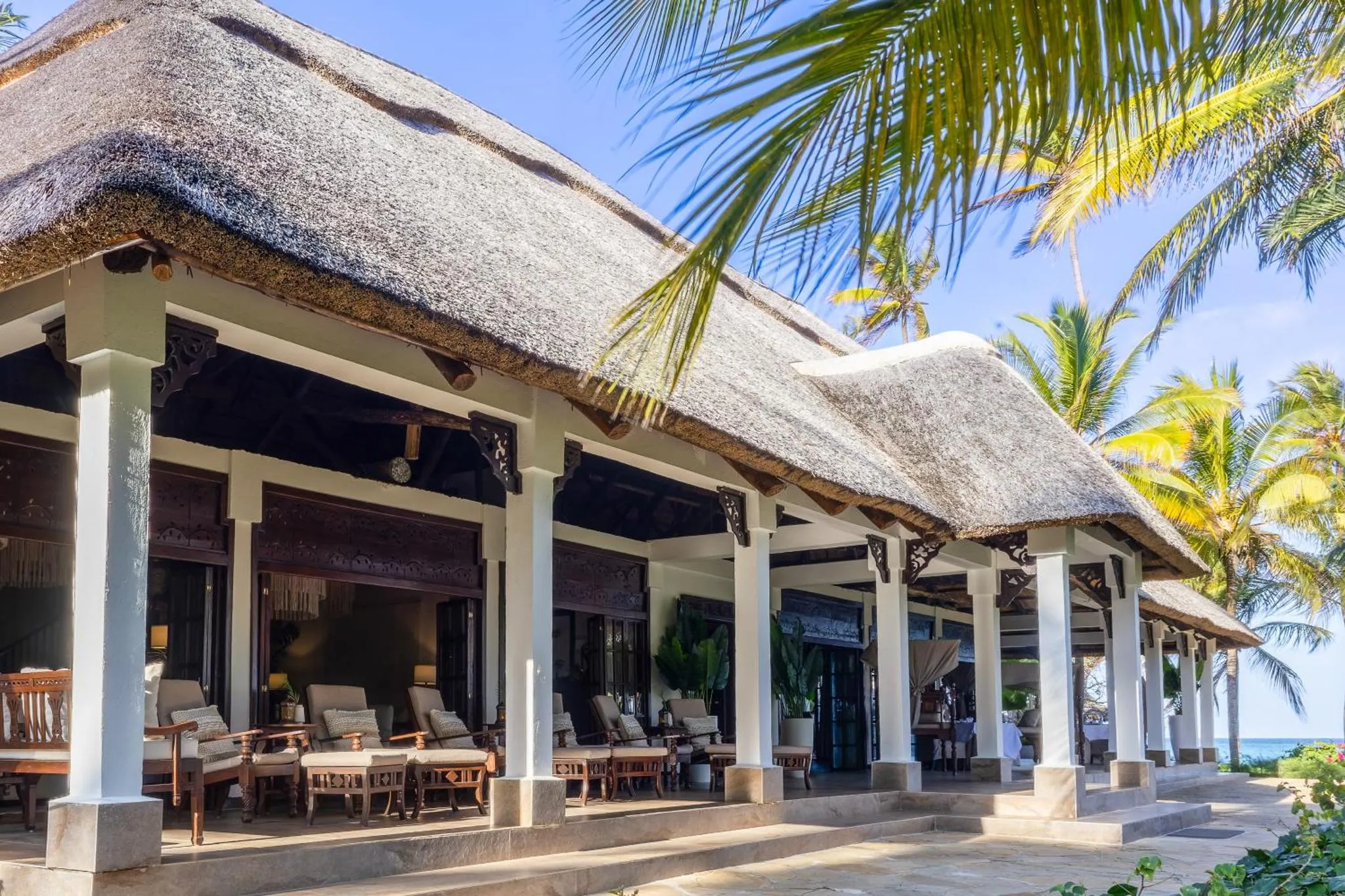 Terrasse ombragée avec mobilier de détente face à la mer.