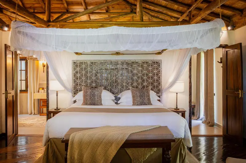 Une chambre lumineuse avec un grand lit à baldaquin et une décoration soignée.