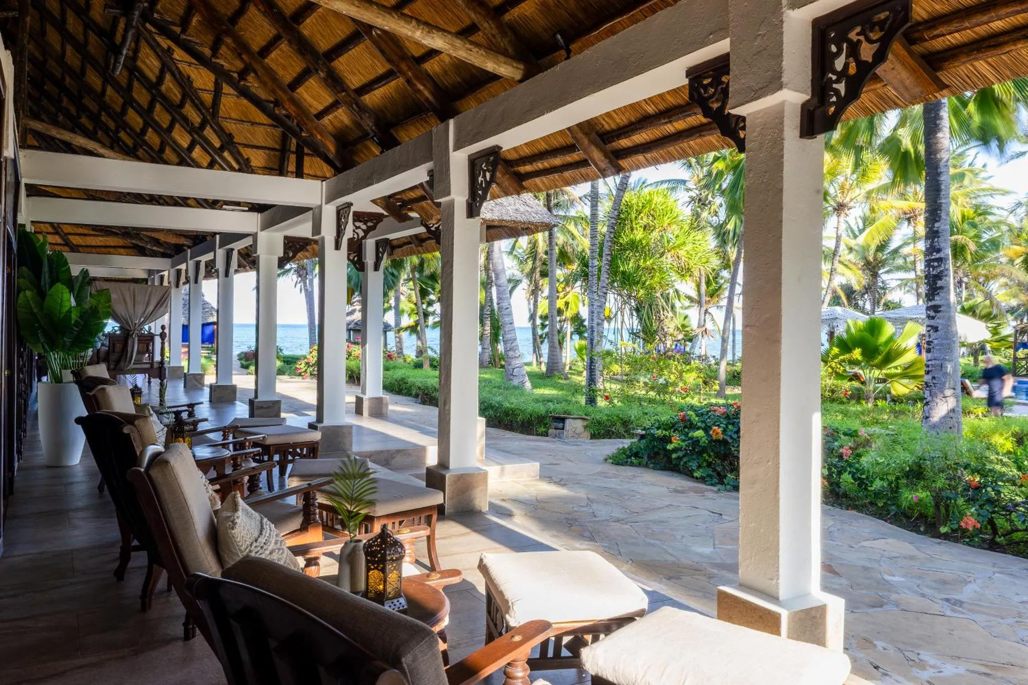Terrasse ombragée avec mobilier de détente face à la mer.