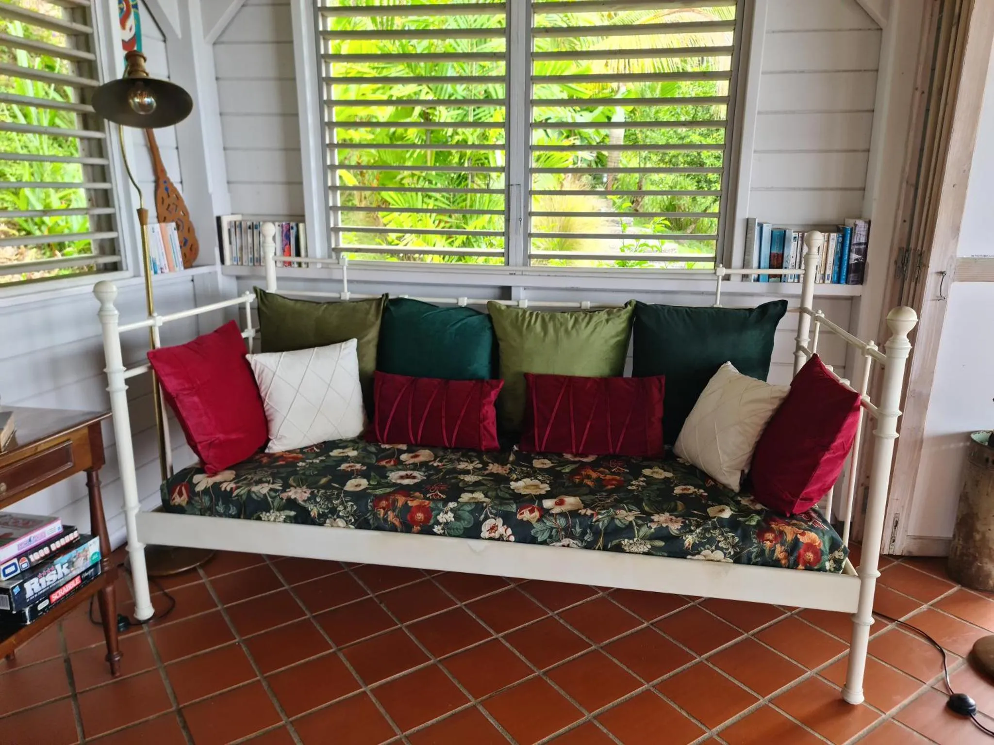 Un canapé fleuri repose sur une terrasse ombragée.