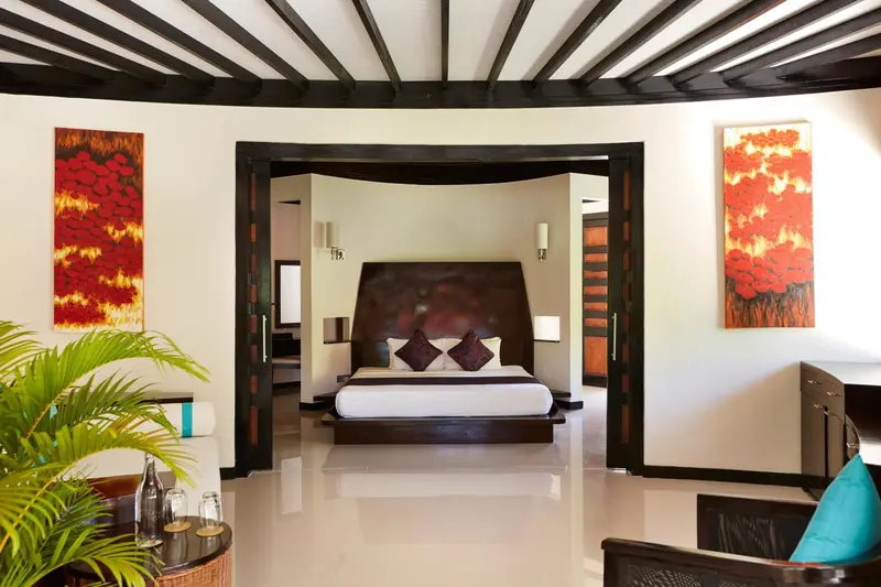 Une chambre spacieuse avec un grand lit et des œuvres d'art colorées.