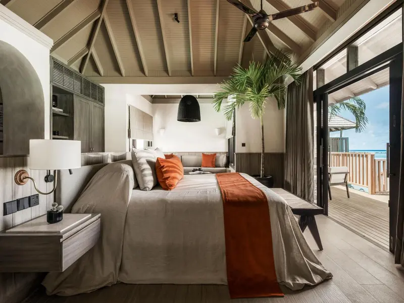 Une chambre lumineuse avec un grand lit et un accès à une terrasse.