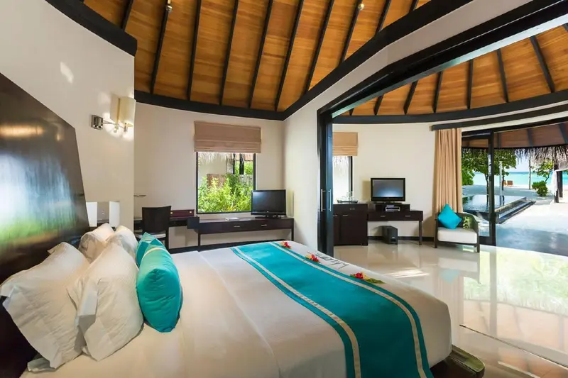 Une chambre lumineuse avec un grand lit et un accès à une terrasse.