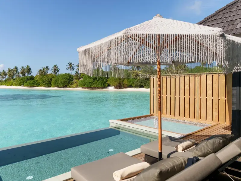 Terrasse avec jacuzzi et vue sur lagon turquoise.