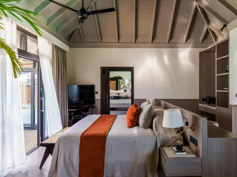 Une chambre lumineuse avec un grand lit et un accès à une terrasse.