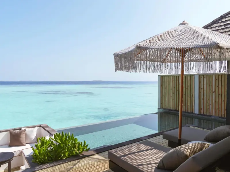 Terrasse avec mobilier d'extérieur et vue sur la mer turquoise.