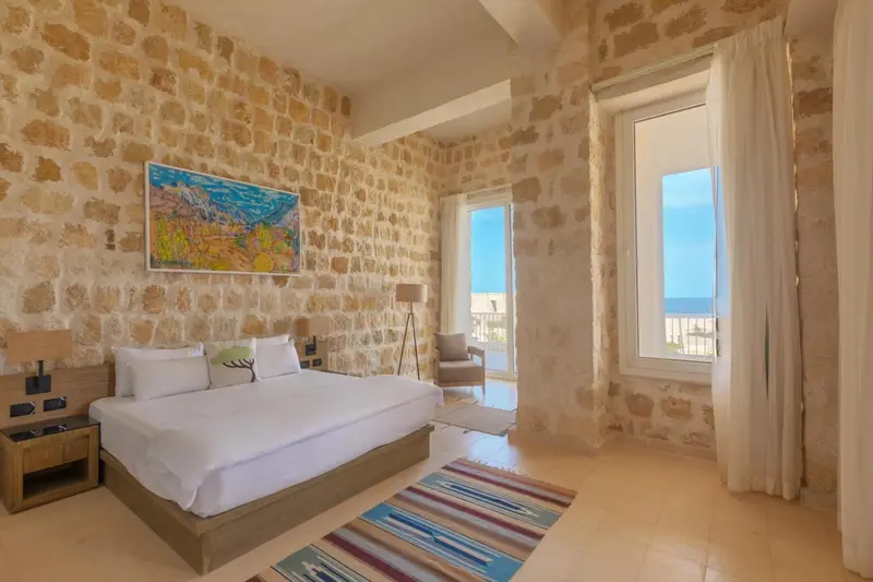 Une chambre lumineuse avec un grand lit et une vue sur la mer.