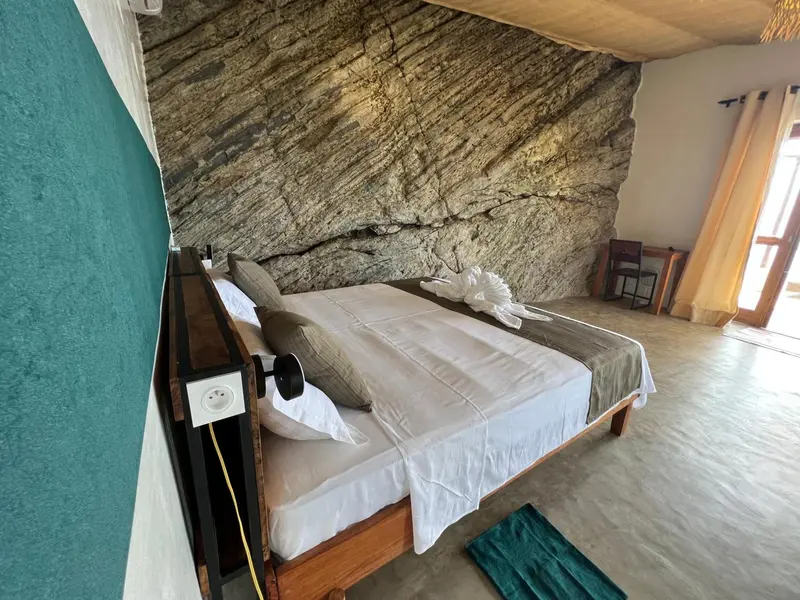 Une vue d'ensemble d'une chambre à coucher avec un lit double et un balcon.