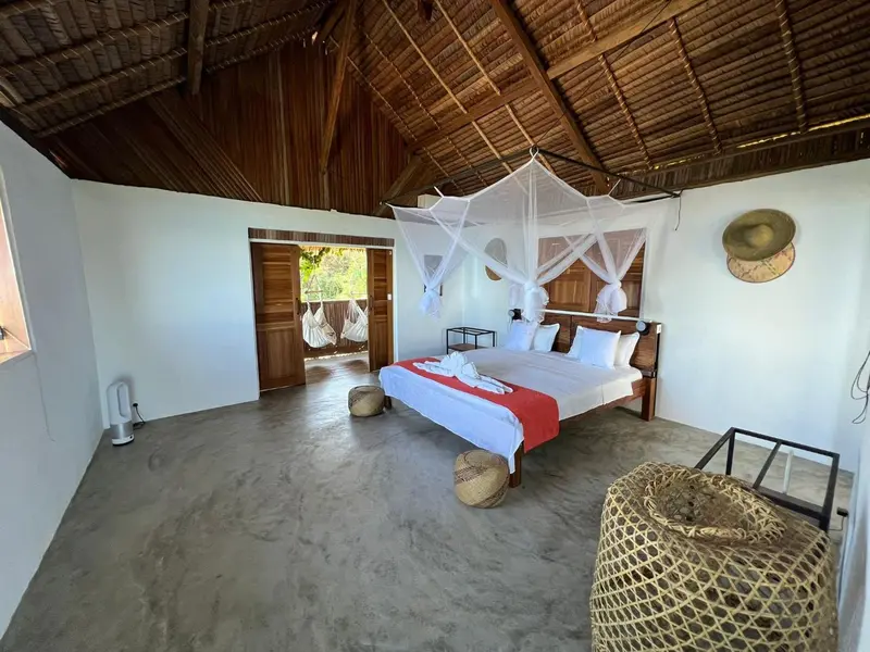 Une chambre lumineuse avec un lit à baldaquin et une décoration naturelle.